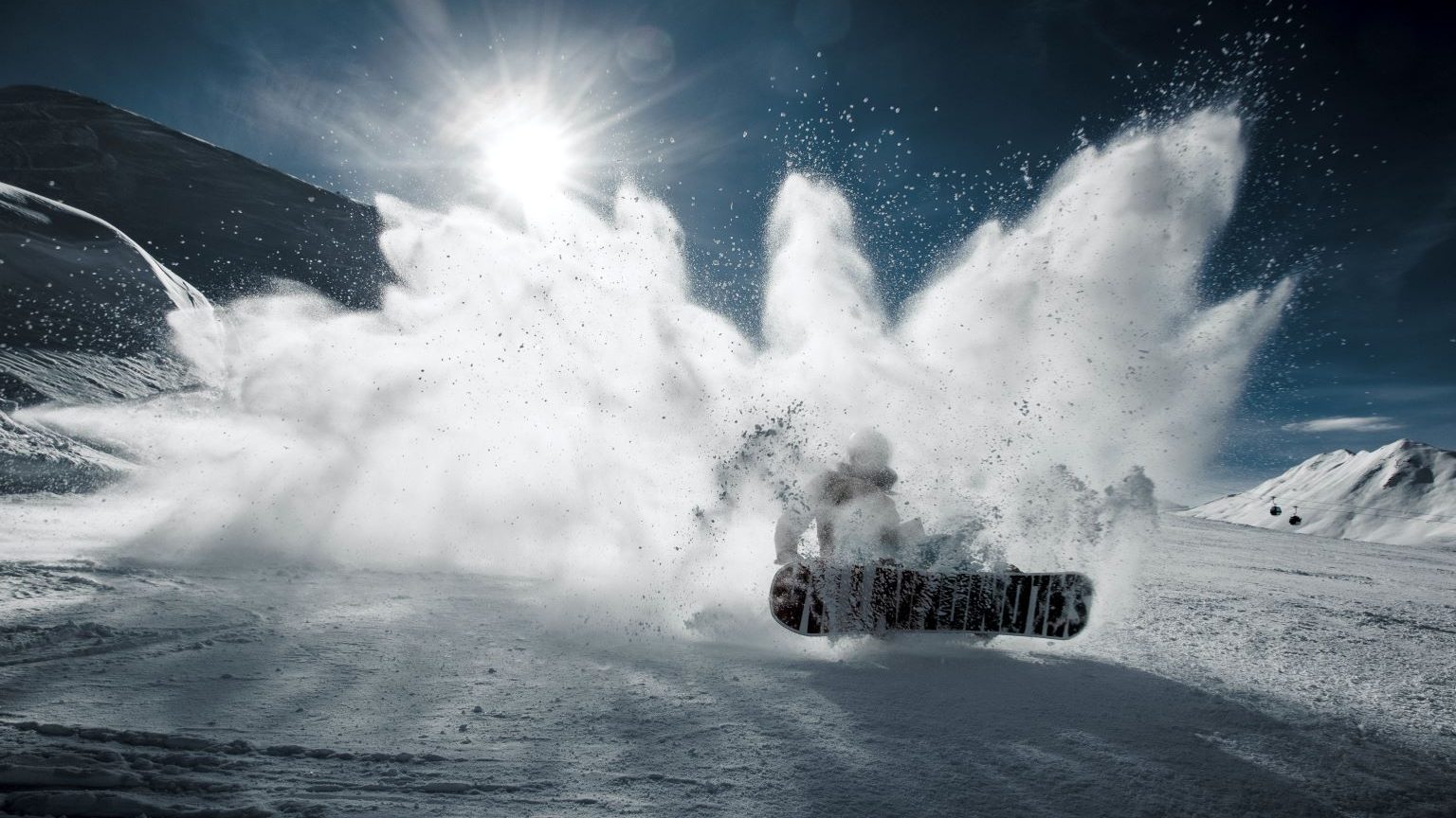 A snowboarder crashes through the snow.