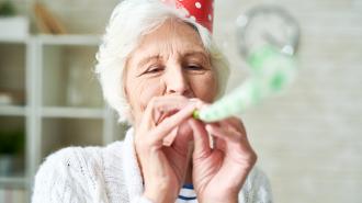 an older woman wearing a party hat