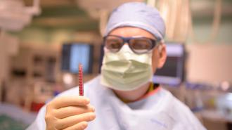 a doctor holding a syringe full of a red liquid