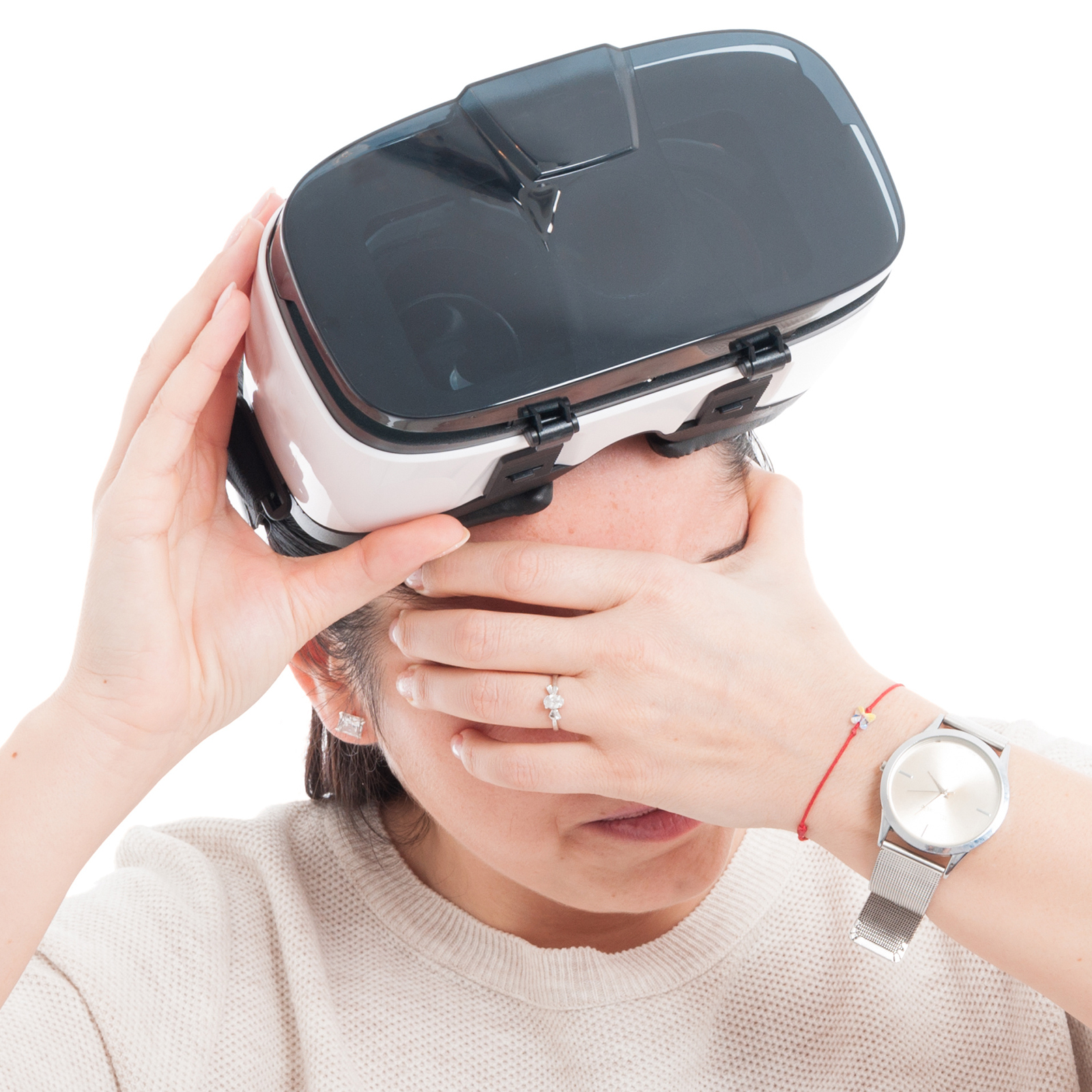 a woman lifting a VR headset off her eyes and holding her temples like she has a headache