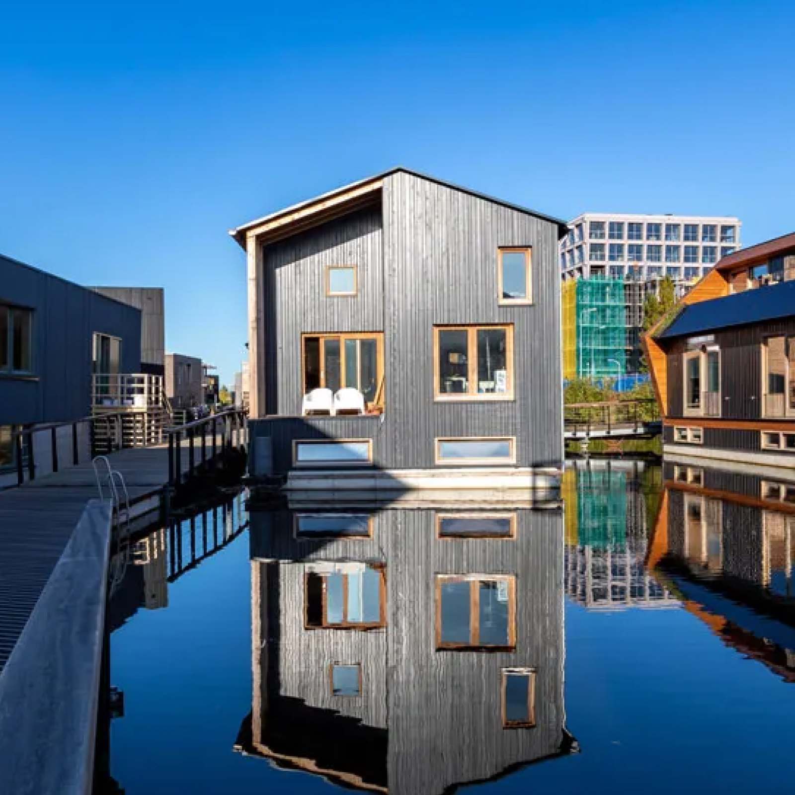 House in Amsterdam on a canal with a reflection in the water.