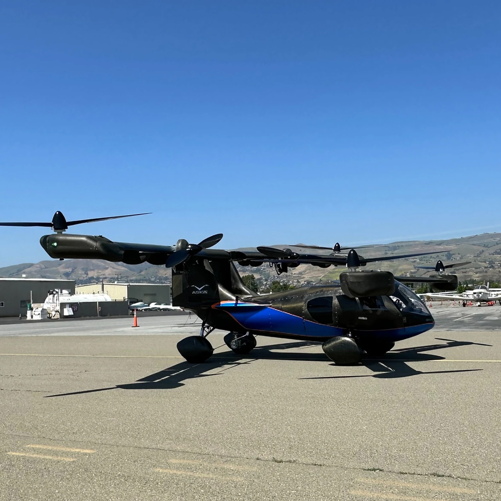 an Aska A5 flying car parked on a tarmac