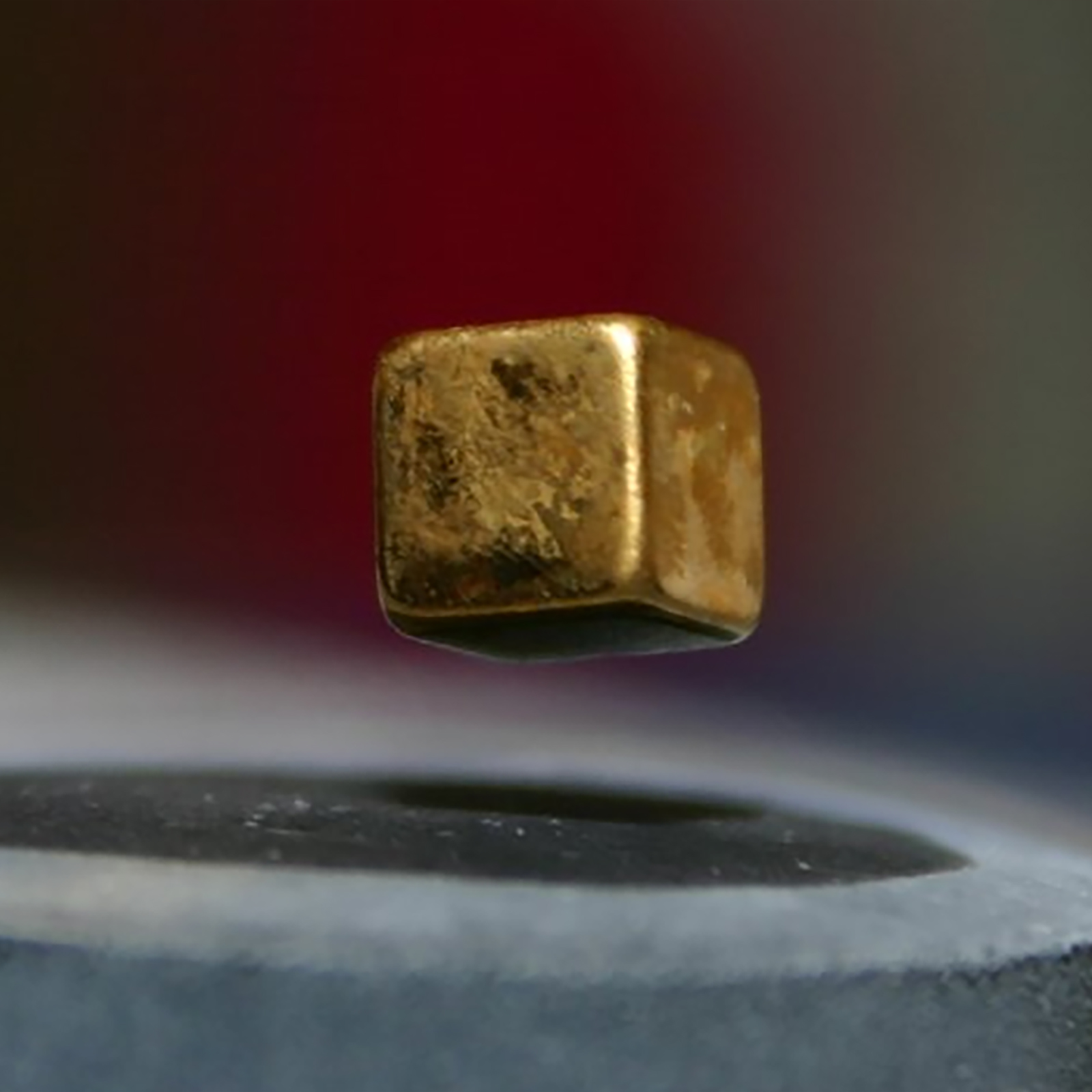 a cube of metal floating above a magnet