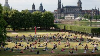 A group of people practicing mindfulness on a grassy field.