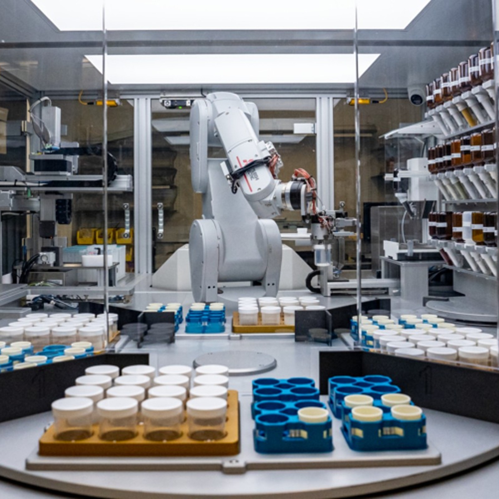 A robot is working in a lab with a lot of jars.