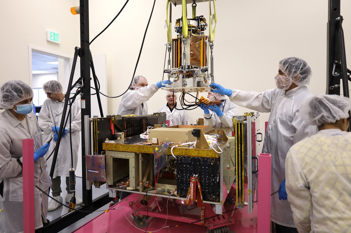 A group of people are working on a device in a lab.