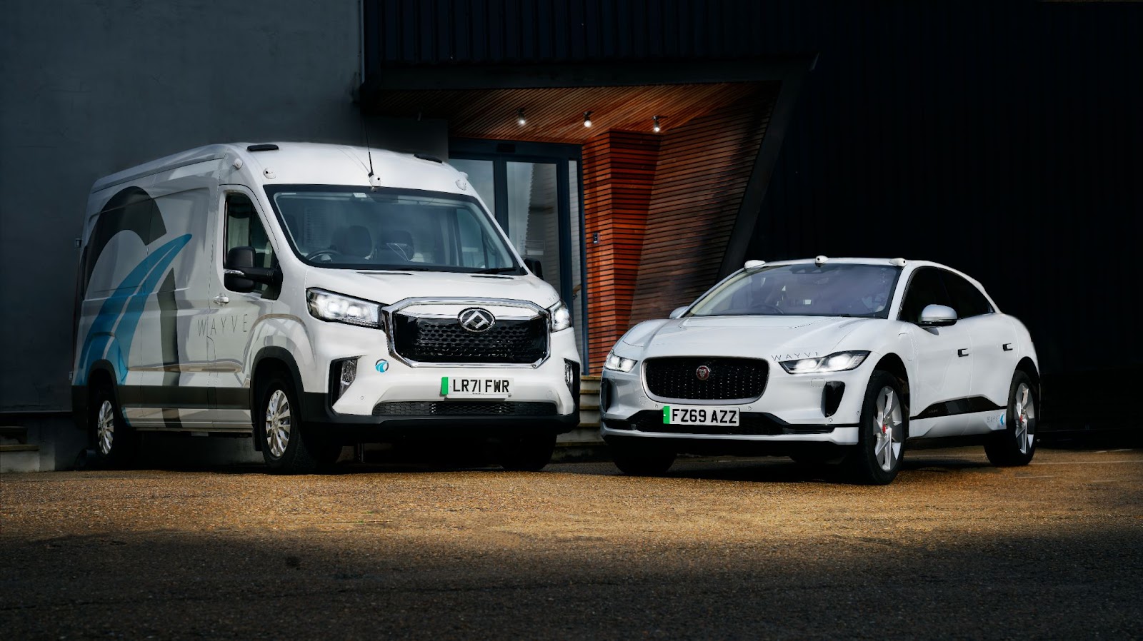 A van and a car equipped with Wayve's AI driver parked side by side