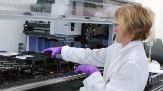 A woman in a lab coat working on a machine