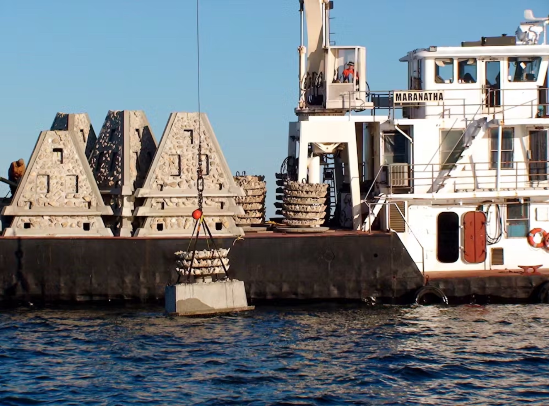 The boat is in the water near artificial reefs.