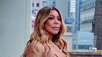 A woman with highlighted hair looking to the side against an urban backdrop, possibly contemplating her diagnosis of frontotemporal dementia.