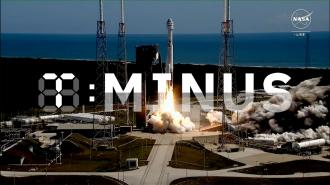 A rocket launches from a coastal launch pad, with "T-Minus" displayed prominently in front. The sky is clear with visible ocean in the background.