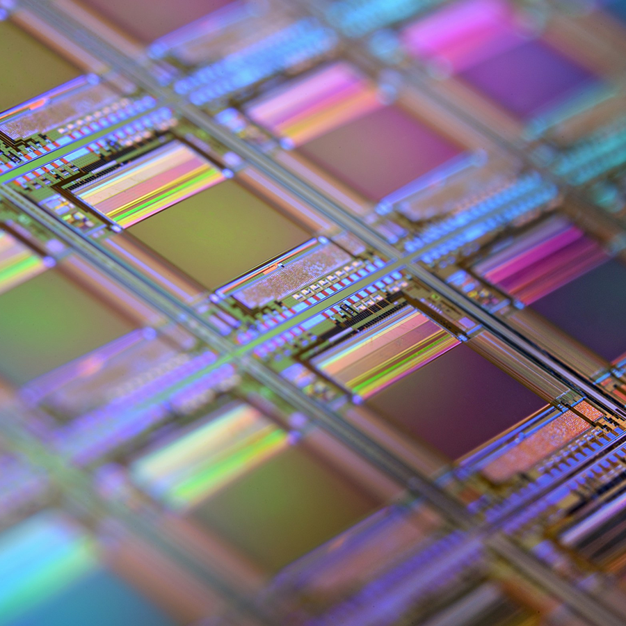 Close-up of a silicon wafer showcasing vibrant, reflective microchips arranged in a grid pattern, symbolizing the technology supercycle.